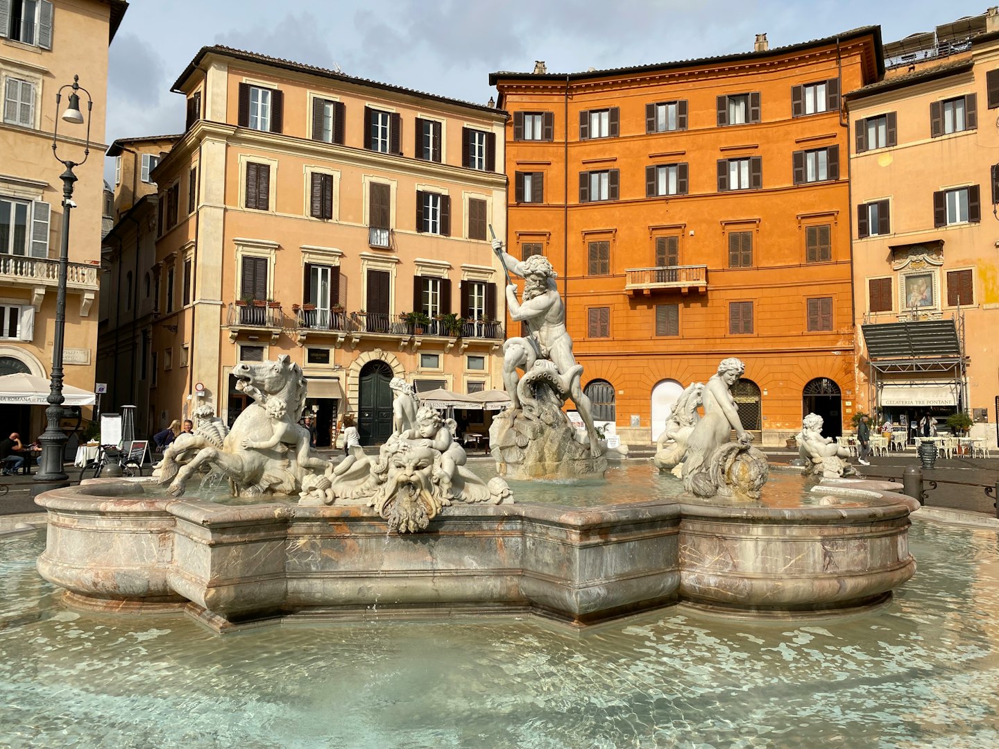 Fontana di Nettuno in una piazza storica con sculture in marmo.